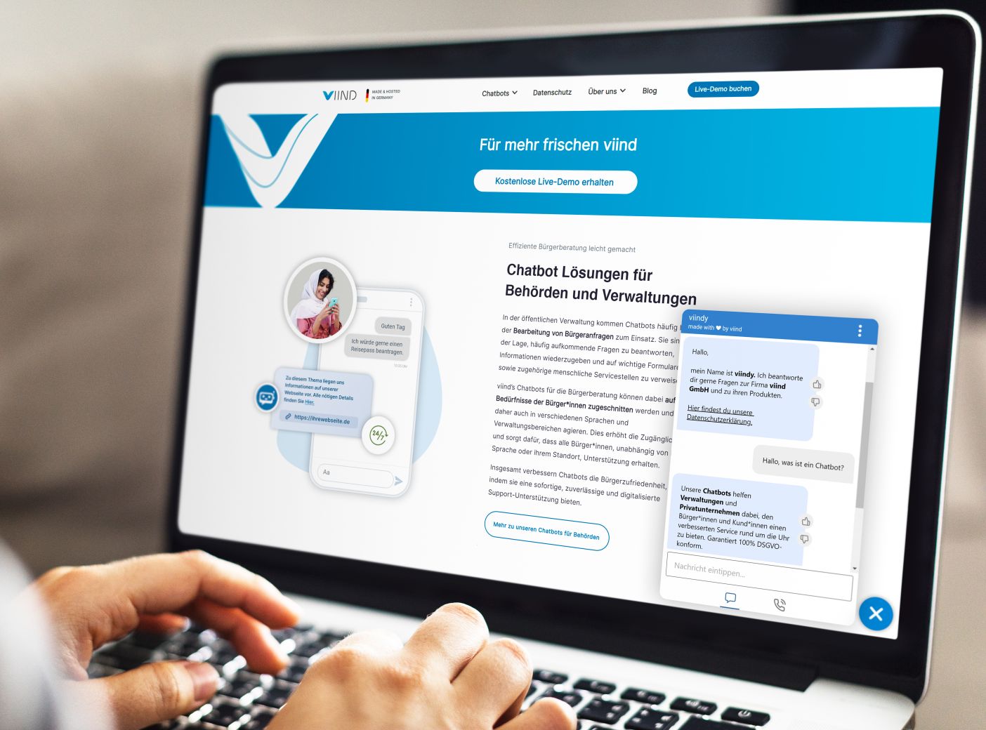 Der Bildschirm eines Laptops zeigt eine Website, auf der Chatbot-Lösungen für Behörden und Verwaltungen beworben werden. Auf der linken Seite des Bildschirms sieht man einen Text mit der Über